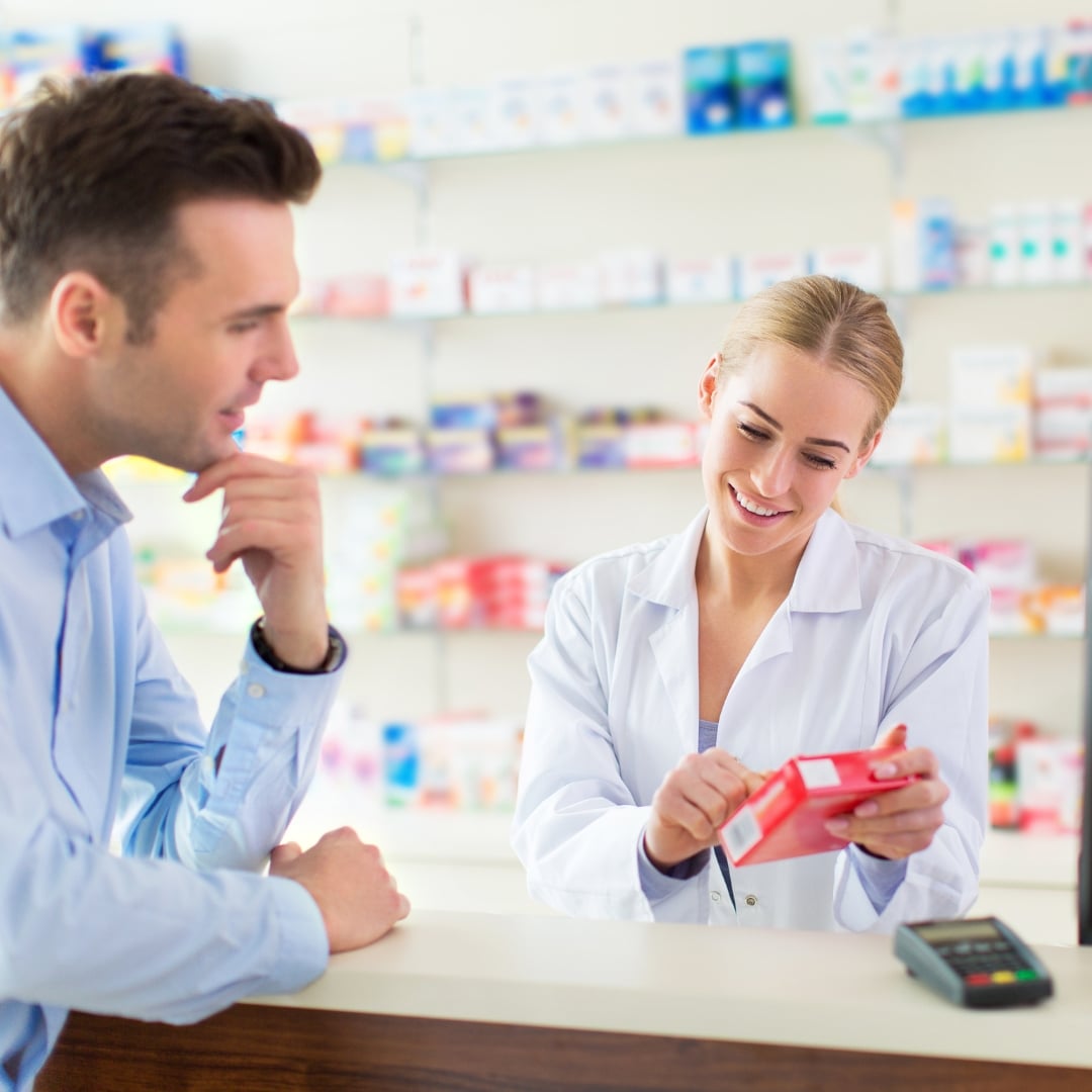 Farmacist Spring FARMA recomandând un produs unui client, la ghișeul farmaciei
